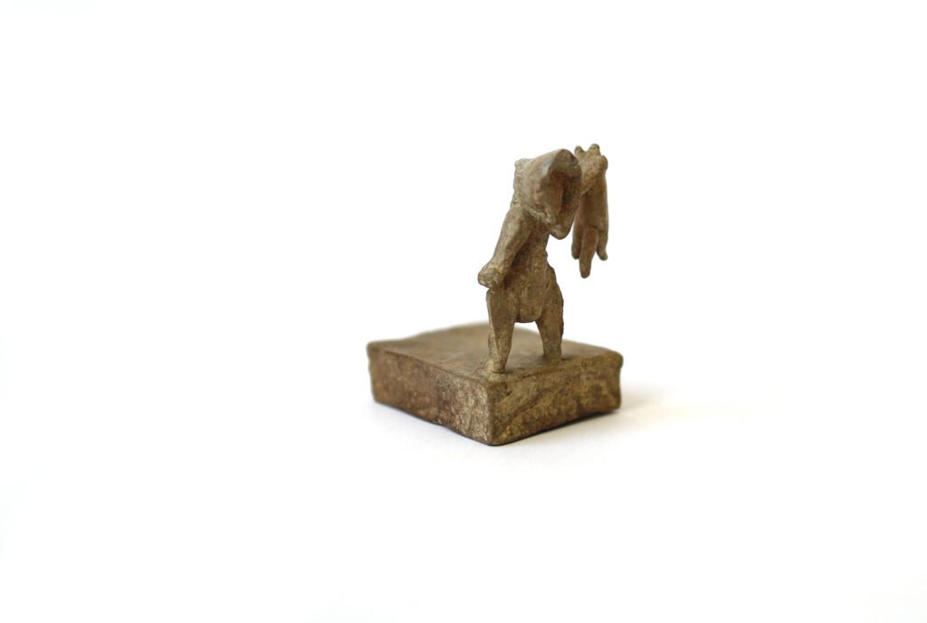 Bronze artwork by Andrew Miguel Fuller. Man presents cat, an absurd cowboy sculpture by AM Andy Fuller